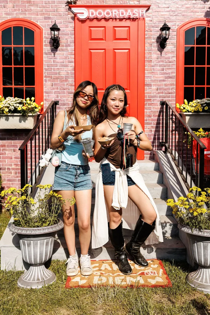 Two fans posing at the red DoorDash door